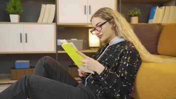 Happy young girl is reading a book. video