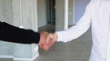 Agent and client shaking hands after done business deal for transfer right of property. The homeowner is happy after receiving the transfer of the right to occupy the home video