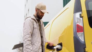 ein Mann Einstecken im elektrisch Auto beim Einkaufen Center beim Elektro Laden Bahnhof elektrisch Auto aufladen ökologisch bewusst Mann Laden seine elektrisch Fahrzeug video