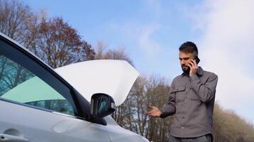 verdrietig Spaans bestuurder roeping auto onderhoud, hebben motor probleem staand in de buurt gebroken auto Aan de weg. auto afbreken concept video