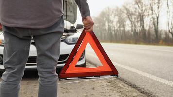 un hombre con un rojo triángulo precaución firmar en un brumoso la carretera video