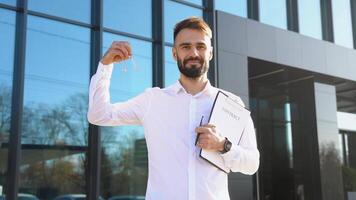 Latin realtor agent with keys and documents in hand against the background of modern house video