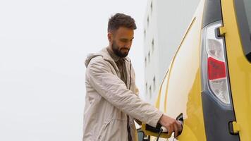 une homme bouchage dans électrique voiture à achats centre à électro mise en charge station électrique voiture recharger écologiquement conscient homme mise en charge le sien électrique véhicule video