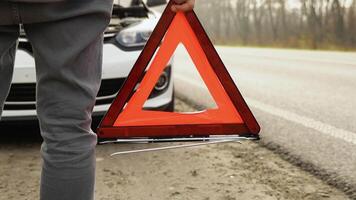 un' uomo con un' rosso triangolo attenzione cartello su un' nebbioso strada. trasporto, in viaggio concetto video