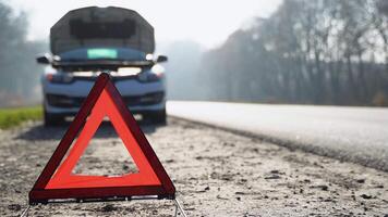 voiture avec des problèmes et un triangle rouge pour avertir les autres usagers de la route video