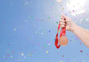 holding a bronze coin celebrate success sky background photo