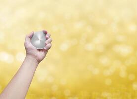 holding a silver coin golden bokeh background photo