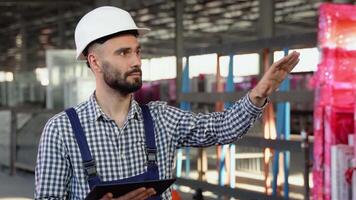 profesional pesado industria ingeniero trabajador vistiendo la seguridad uniforme y difícil sombrero, utilizando tableta computadora video