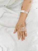 Arm of woman lying sick in hospital photo