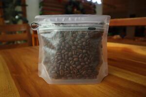 Transparent pouch contains roasted coffee beans photo