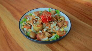 Top view of a bowl of gado-gado sprinkled with peanut sauce, suitable for seasoning satay, ketoprak, and others photo