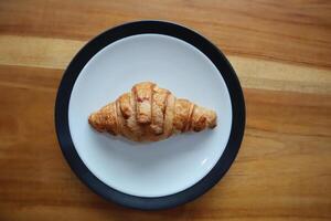 un plato de ahumado carne de vaca croissants en el mesa antecedentes foto