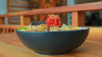 Top view of a bowl of gado-gado sprinkled with peanut sauce, suitable for seasoning satay, ketoprak, and others photo