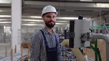 Operator of machine. Industrial worker wearing safety uniform and helmet indoors in factory video