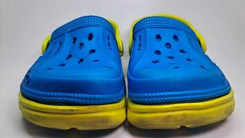 a pair of blue and yellow sandals with holes photo