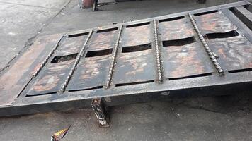 a metal table with holes in it sitting on the sidewalk photo