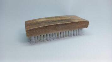 a wooden brush with white bristles on a white surface photo