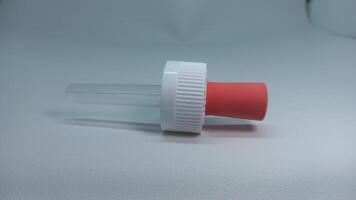 a small plastic bottle with a red cap photo