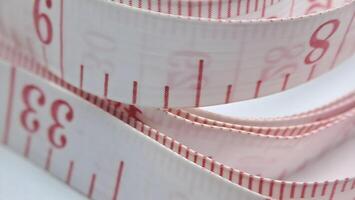 un medición cinta es mostrado con rojo y blanco rayas foto