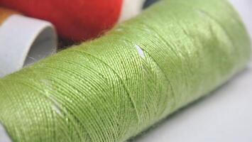 a spool of thread with green and red colors photo