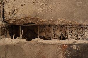 The damaged wall is visible to the internal steel bar. The plaster should be repaired With mortar to make it work. photo