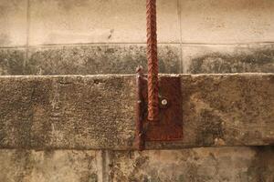 The damaged wall is visible to the internal steel bar. The plaster should be repaired With mortar to make it work. photo