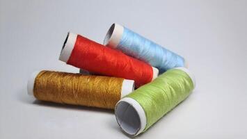 four spools of thread with different colors photo