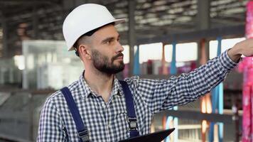 professionnel lourd industrie ingénieur ouvrier portant sécurité uniforme et difficile chapeau, en utilisant tablette ordinateur video