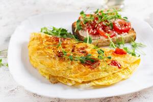 Omelette with cheese and toast with tomatoes on white plate. Frittata - italian omelet. photo