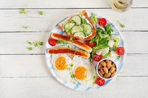 English breakfast. Keto breakfast. Fried egg, beans, chicken sausage. Top view, flat lay photo