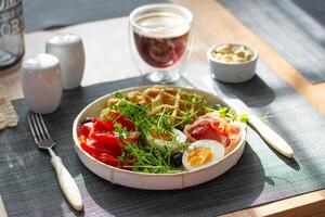 English breakfast. Boiled egg, jamon, waffles and green herbs. photo