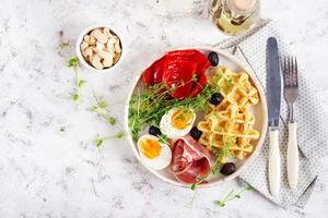 English breakfast. Boiled egg, jamon, waffles and green herbs. Top view, flat lay photo