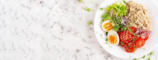 Breakfast oatmeal porridge with boiled eggs and fresh vegetables. Healthy balanced food. Trendy food. Top view, banner photo