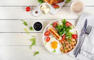 Inglés desayuno. ceto desayuno. frito huevo, frijoles, pollo salchicha y café taza. parte superior vista, plano laico foto