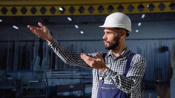 Bearded man gesturing and shouting during working process. Serious manager in uniform giving commands to workers on industrial warehouse video