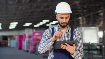 Professional heavy industry engineer worker wearing safety uniform and hard hat, using tablet computer video