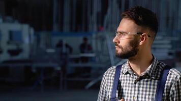 ritratto di Manuale uomo lavoratore è in piedi con fiducioso nel uniforme a industria fabbrica video