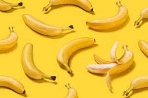 Banner bananas with hard shadows creative pattern on yellow background flat lay photo