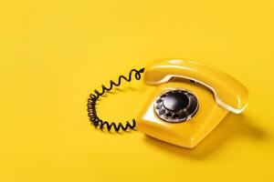 Yellow old stylish Phone, telephone with dial on yellow background copy space for your text banner photo