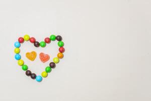 Heart shaped Candy and multi colored candy on Isolated on White Background. photo