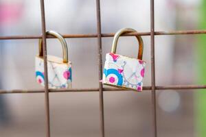 A close up of love padlocks attached to a railing photo