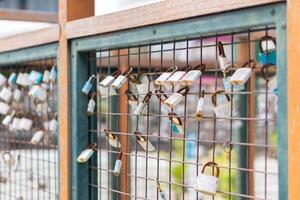 A close up of love padlocks attached to a railing photo