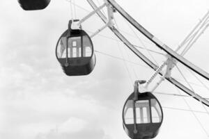 cerca arriba negro y blanco ferris rueda en diversión parque con nube antecedentes foto