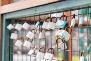 A close up of love padlocks attached to a railing photo