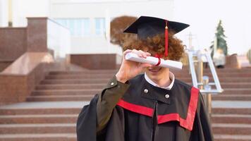 Funny red -haired graduate corrects the hairstyle with a diploma video