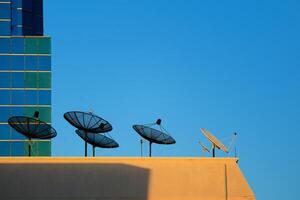 satélite plato en parte superior de un alto edificio foto