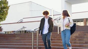 deux élégant élèves marcher près le Campus et sourire. amical caucasien gars et fille marcher ensemble près le université. lent mouvement video