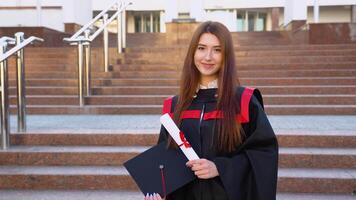gelukkig tevreden met zijn succes in studie een Universiteit afstuderen staat buitenshuis met een meester hoed en een diploma in haar handen video