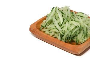 Grated cucumber in a bowl on white background. Healthy vegetarian ingredients photo