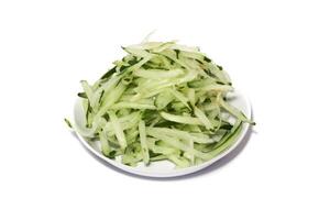 Grated cucumber in a bowl on white background. Healthy vegetarian ingredients photo